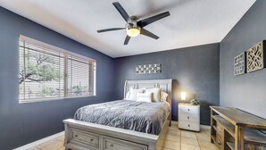 A bedroom with a bed, a nightstand, a dresser, a ceiling fan, and a window with blinds. - Game Room, Playset! Family-friendly Tucson Getaway (Tucson)