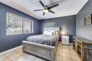 A bedroom with a bed, a nightstand, a dresser, a ceiling fan, and a window with blinds. - Game Room, Playset! Family-friendly Tucson Getaway (Tucson)