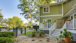 A two-story house with a front porch, a gated yard, and a small garden with stepping stones. - 1 BR Ocean Inlet View With Private Pool (Murrells Inlet)