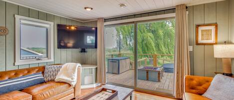 Un salón acogedor con un sofá de cuero, una mesa de centro de madera y un ventanal con vistas al exterior.