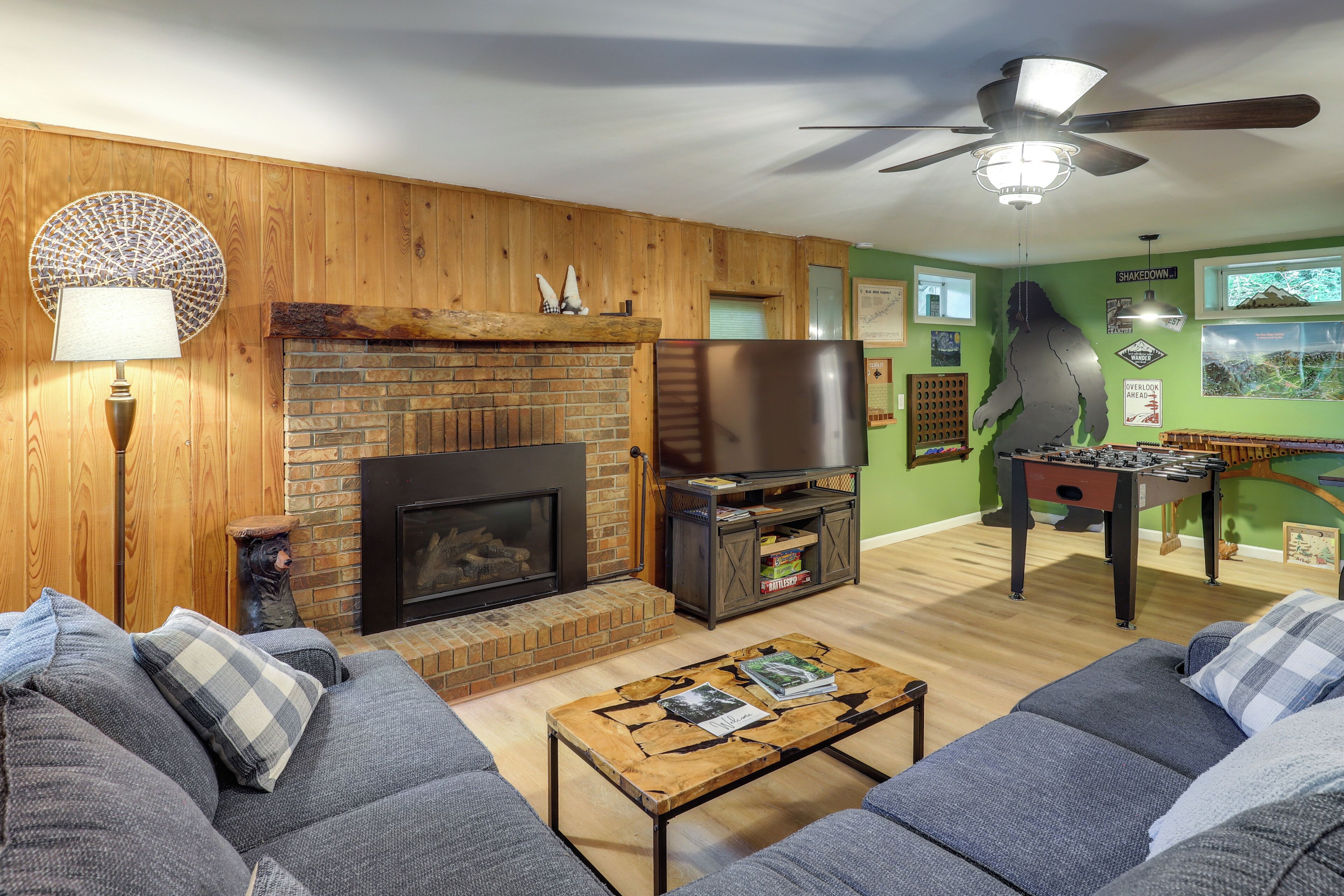 Una sala de estar acogedora con chimenea, televisor y mesa de futbolín.