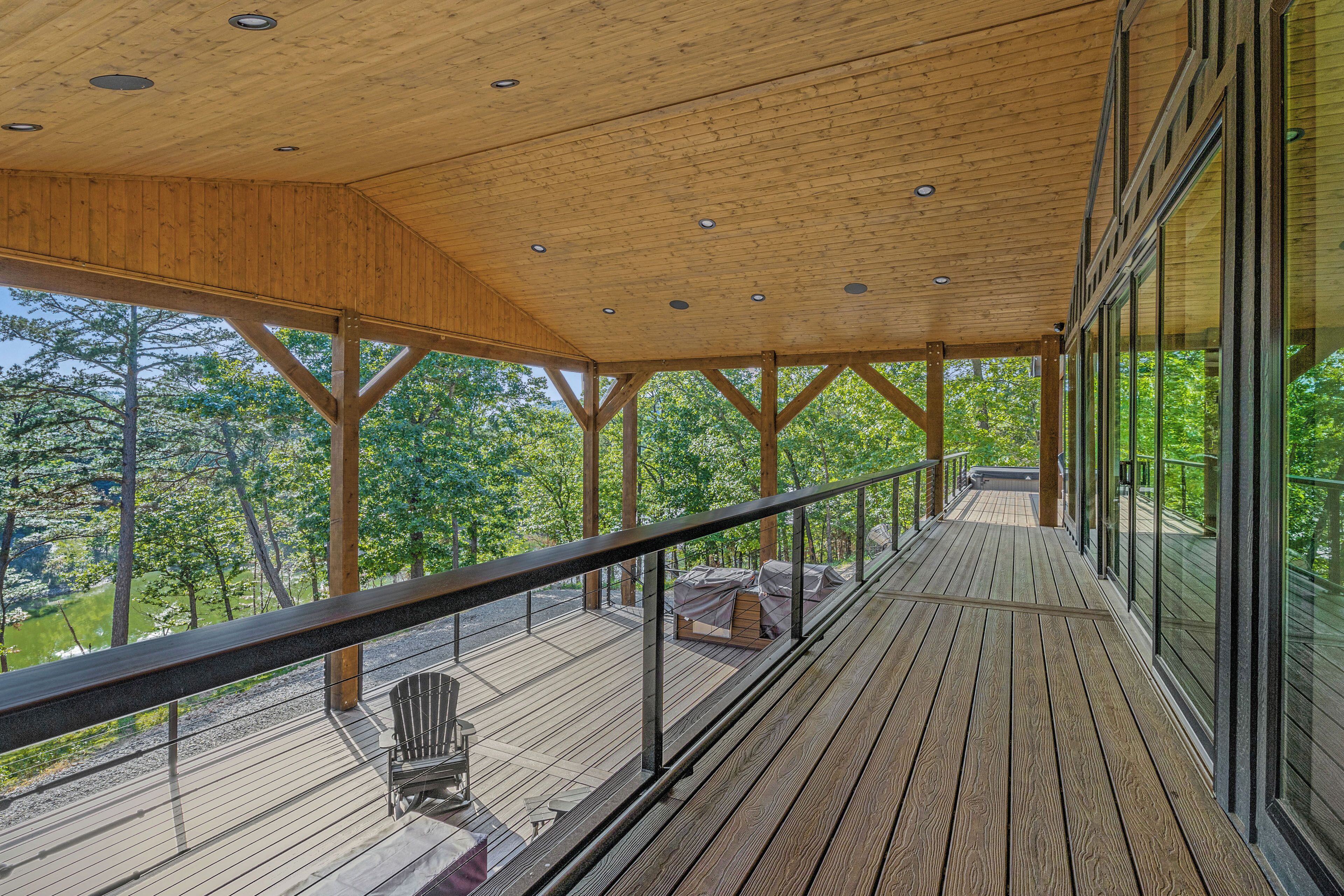 A wooden deck with a railing, a chair, and a table.