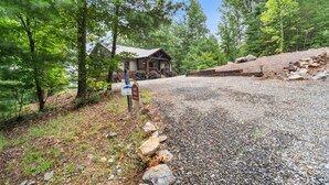 A lodge with a gravel driveway leading to a wooden building, surrounded by trees. - Mt Views, Deer Feeder, EV Chrgr, Hot Tub, Fire Pit (Morganton)
