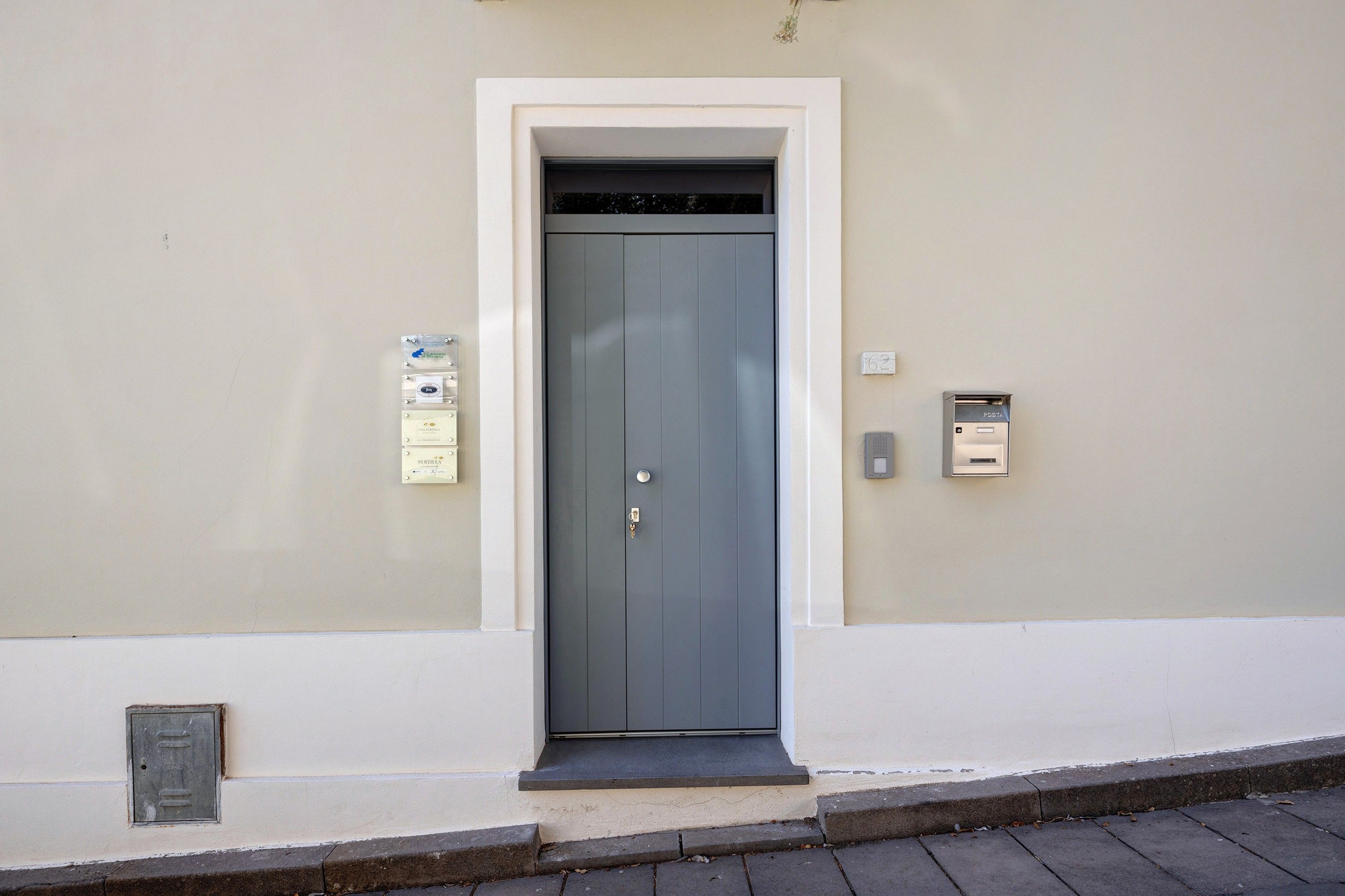 Une porte avec une serrure et une fente pour le courrier, le tout situé sur le mur à côté.