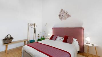 Ein Schlafzimmer mit einem Bett, Nachttischen, einem Hängesessel und einer Wanddekoration.