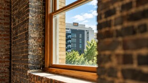 A window with a view of a building with multiple floors and a sign that reads 'our'. - Downtown Knoxville Loft | Near Market Square, UT & Neyland | Free Parking (Knoxville)