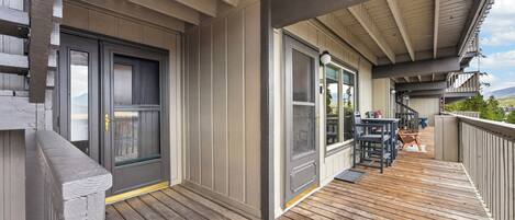 Una terraza de madera con un espacio cubierto, una puerta y una ventana.