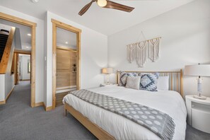 A bedroom with a bed, bedside tables, a ceiling fan, and a macrame wall hanging. - Arrow At Winter Park Unit 294 Outdoor HT, private deck, downtown luxury townhome (Winter Park)