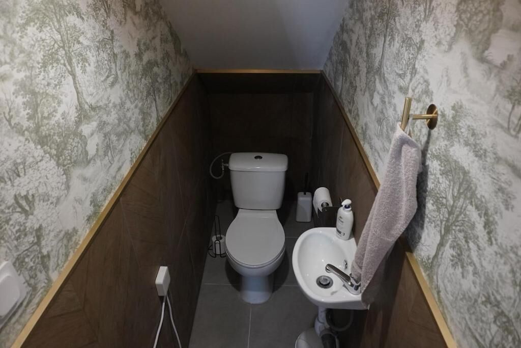 Ein kleines Badezimmer mit Toilette, Waschbecken und Handtuchhalter.