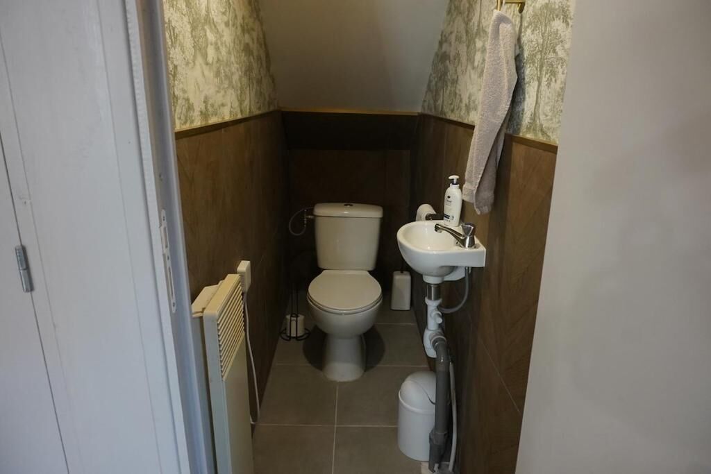 Une petite salle de bain avec des toilettes, un lavabo et un radiateur.
