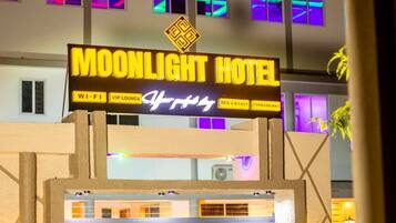 A sign for the Moonlight Hotel with amenities like Wi-Fi, VIP lounge, and food & drinks.