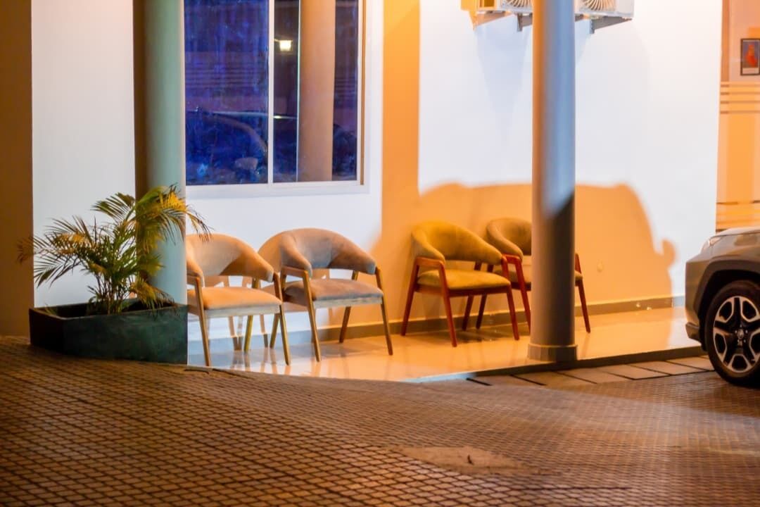 Un hall d’hôtel avec un espace salon, une plante en pot et une voiture garée à l’extérieur.
