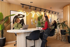 A modern office space with a round table, chairs, and potted plants. - Student Only Kyle Park House (Glasgow)