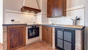 Una cocina compacta con horno integrado, lavavajillas y armarios de madera.