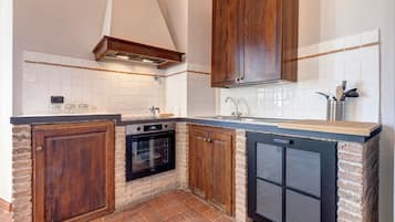 A compact kitchen with a built-in oven, a dishwasher, and wooden cabinets.