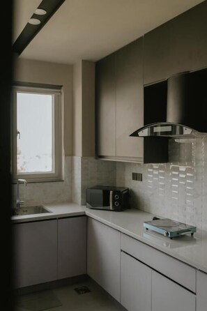 Departamento, vista a la ciudad | Cocina privada | Frigobar, microondas, horno y parrilla de estufa 