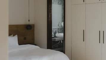 A bedroom with a bed, a bedside table, a ceiling fan, and a wardrobe.