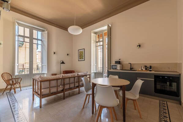 A modern kitchen with a dining area, a sofa, and a view of the outside. - Roma 1923 by Wonderful Italy (Palermo)