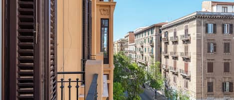 Un edificio a più piani con balconi, vista sulla strada e cielo sereno.