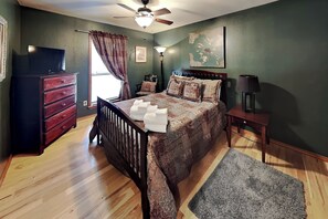 A bedroom with a bed, dresser, nightstand, lamp, and a ceiling fan. - Casa Aurora | Serene Sanctuary + Large Deck (Ruidoso)