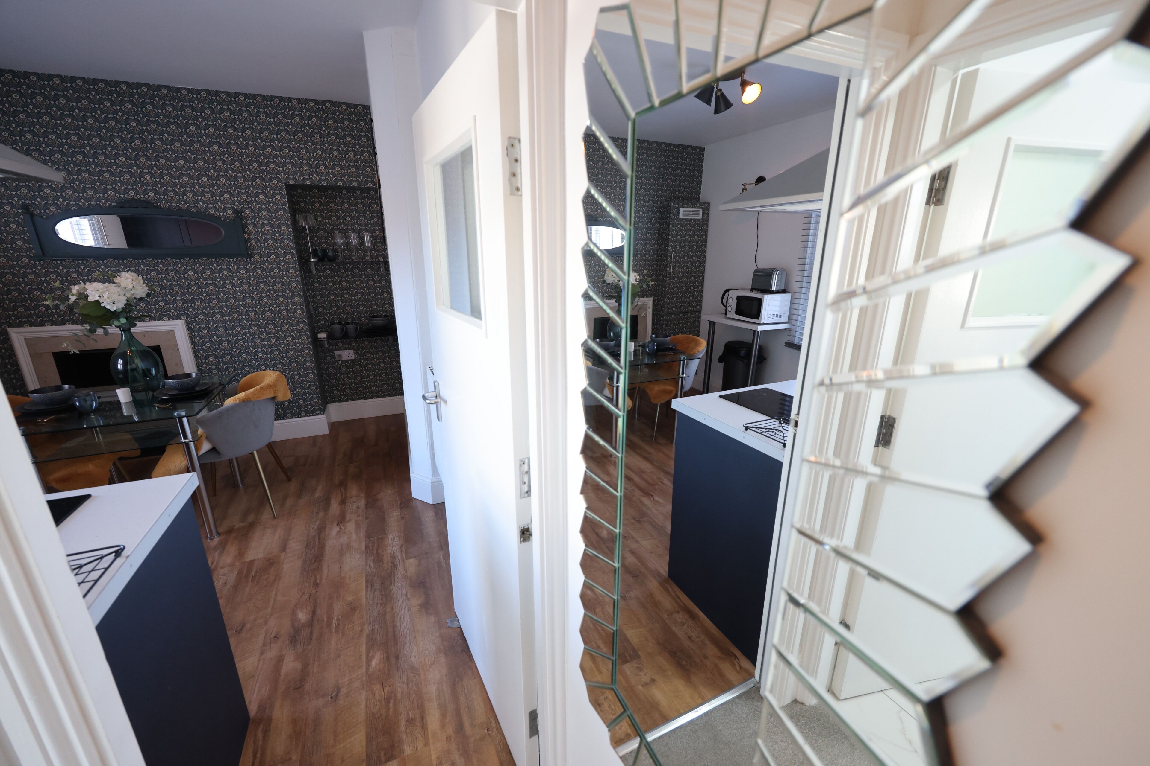 A modern kitchen with a microwave, a dining table, and chairs.