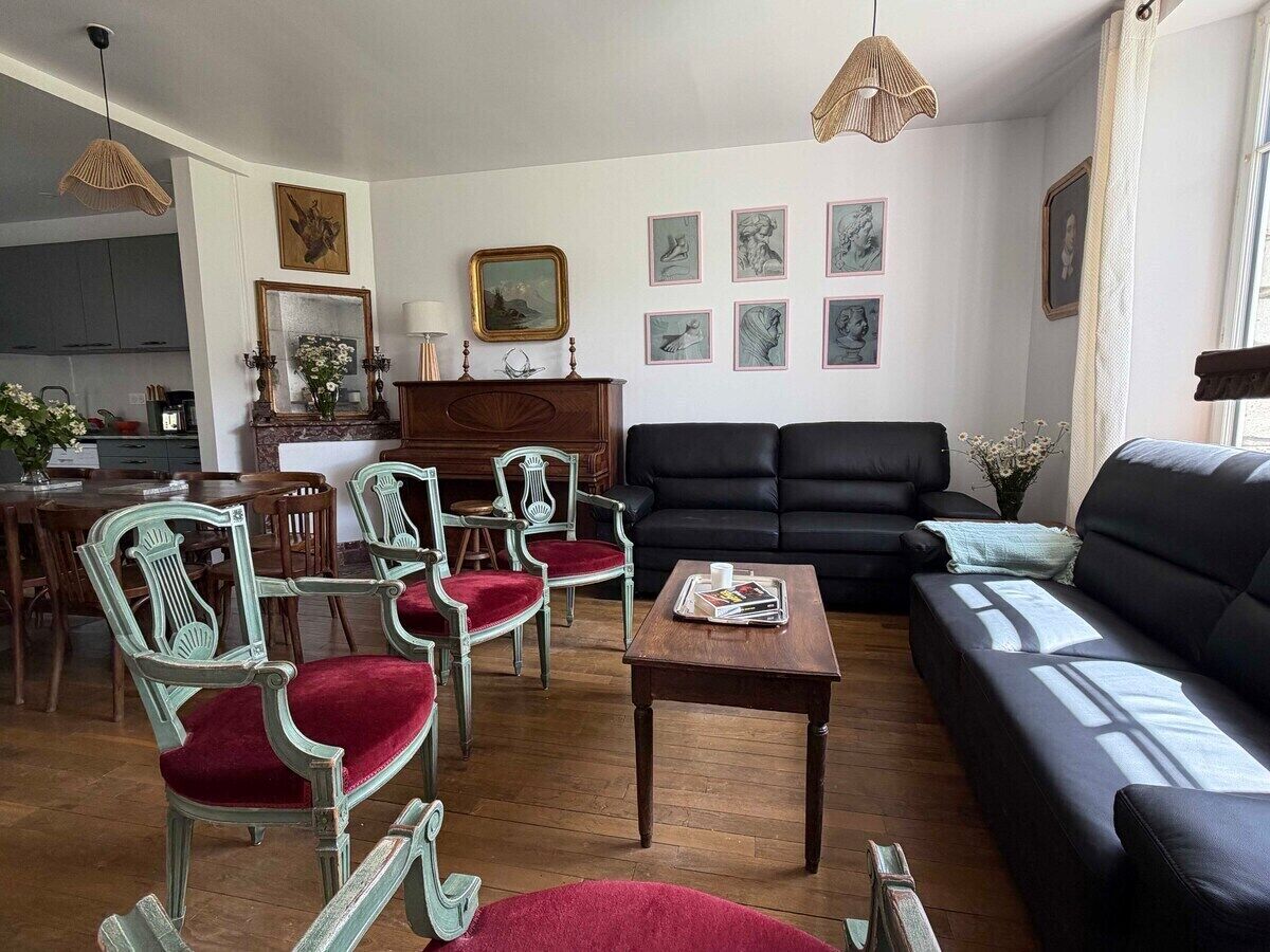 Der Salon des Château de Mainville mit seinen zwei bequemen Sofas und eleganten Sesseln sowie einem gestimmten Klavier für Musikliebhaber.