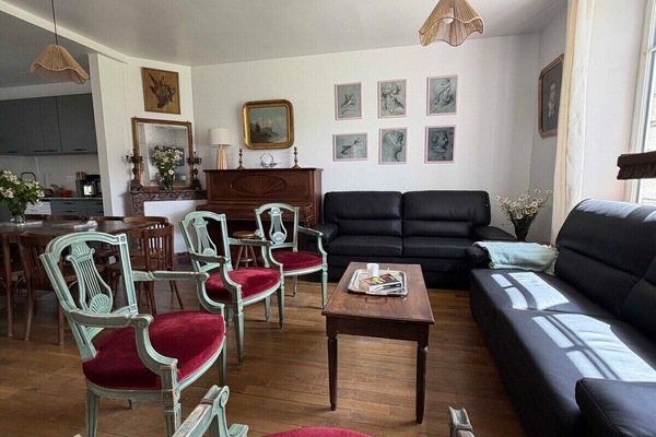Der Salon des Château de Mainville mit seinen zwei bequemen Sofas und eleganten Sesseln sowie einem gestimmten Klavier für Musikliebhaber.
