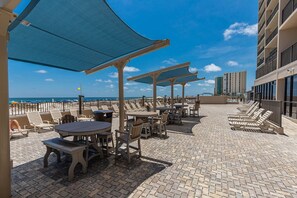 Eine Dachterrasse mit Sitzgelegenheiten im Freien und Blick auf das Meer.