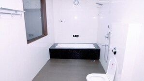 Un baño moderno con inodoro blanco, un lavamanos rectangular y una ducha.