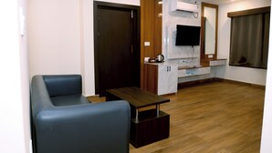 Una sala de estar moderna con un sofá, una mesa de centro y un televisor montado en la pared.