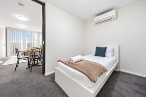 Une chambre à coucher moderne avec un lit, un bureau et une chaise.