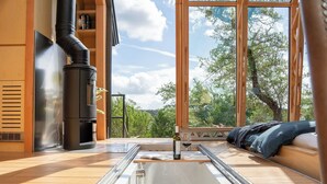 A modern interior with a glass table, a built-in stove, and a view of the outdoors.