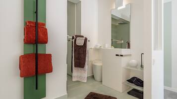 Un baño moderno con un toallero verde, un lavabo blanco y un espejo.