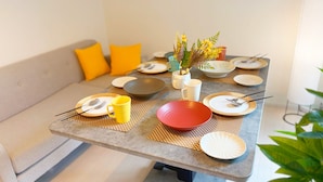 A dining table set with plates, bowls, and utensils, with a vase of flowers in the center. - Renovated 2K apartment | 4-minute walk from JR Shin-Koiwa Station | Accommodates up to 4 guests | Direct access to Akihabara, Tokyo in 13 minutes (葛飾区)