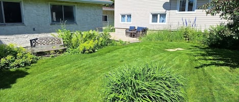 A residential property with a well-maintained lawn, a patio with outdoor furniture, and a satellite dish.