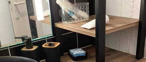 A laundry area with a washing machine, a sink, and a mirror.