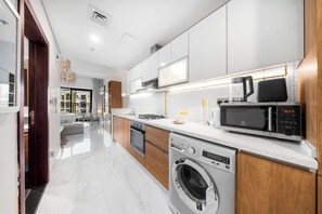 A modern kitchen with a built-in oven, microwave, and dishwasher. - Classy Studio in Al Barsha South that Sleeps 2 (Dubai)
