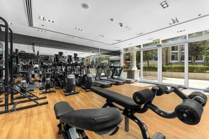 A gym with various exercise equipment, including treadmills and weight machines, and a bench press area. - Classy Studio in Al Barsha South that Sleeps 2 (Dubai)