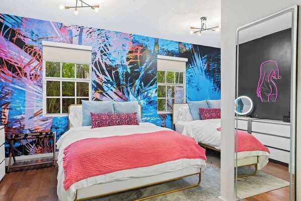 A bedroom with two beds, a large abstract mural, and a mirror. - Vibrant Art-Filled Pool Gem near Beach & Las Olas! (Fort Lauderdale)