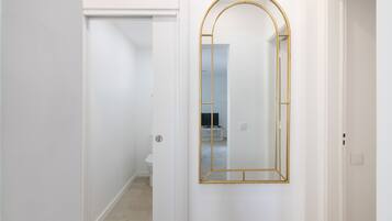 A hallway with a white door and a gold-framed mirror.