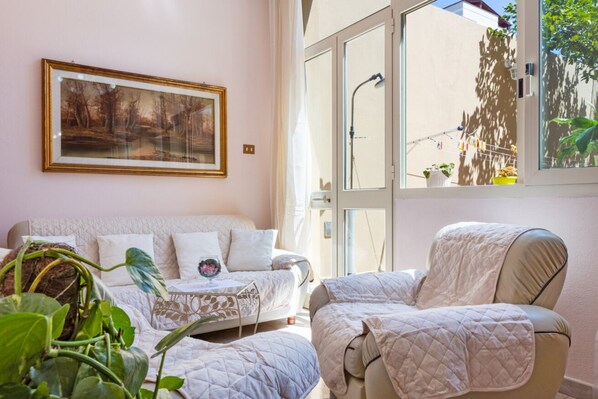 Ein Zimmer mit einem Bett, einem Sessel, einem Fenster mit Aussicht und einem gerahmten Bild an der Wand.