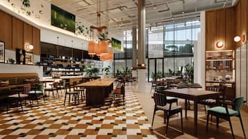A spacious restaurant with a checkered floor, wooden furniture, and hanging pendant lights.