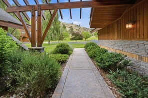 A stone pathway leading to a building with wooden beams and stone walls. - Sleeping Creek Ranch (Hamilton)
