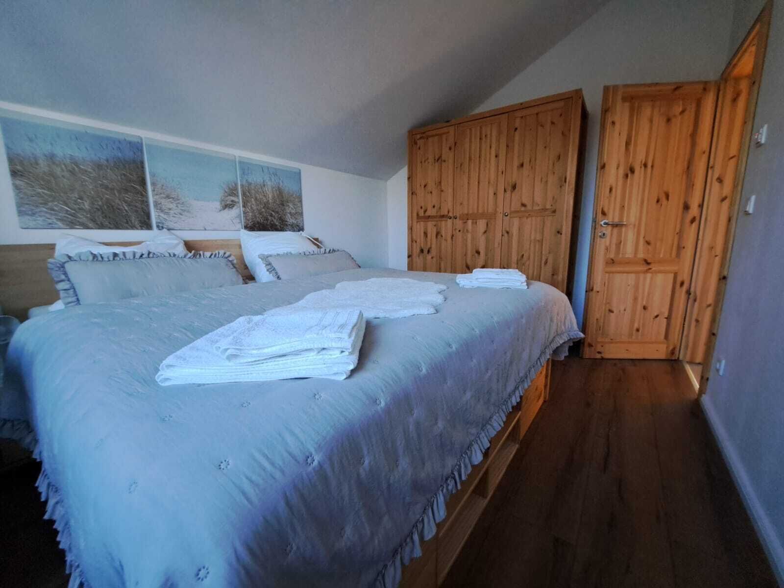 Une chambre à coucher avec un lit, une armoire en bois et une porte.