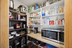 A kitchen with a microwave, coffee maker, and various food items on shelves. - Private Hot Tub with Perfect Mountain Views (Stevensville)