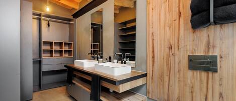 A modern bathroom with two sinks, a mirror, and wooden paneling.