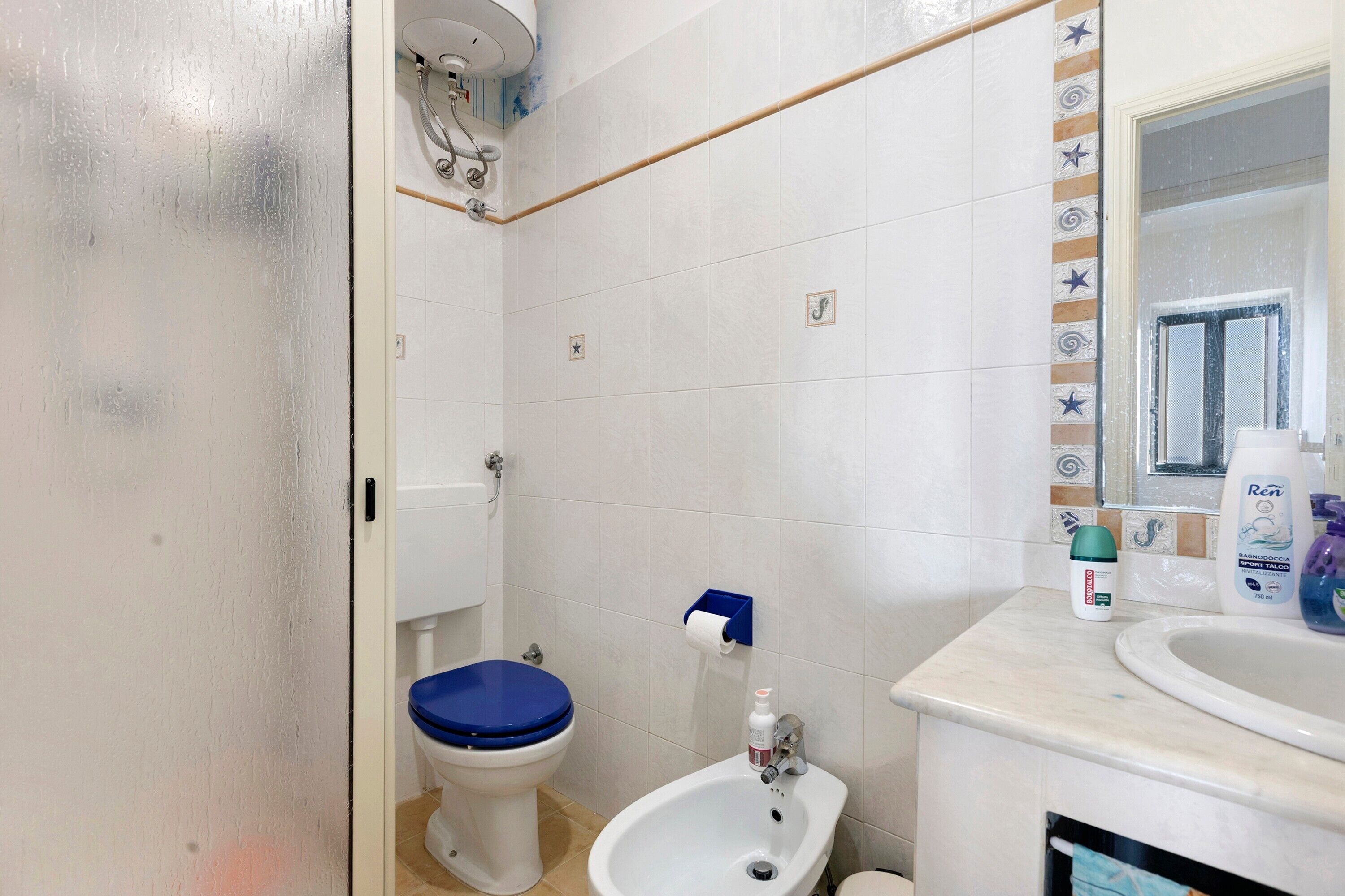 Un bagno con servizi igienici, bidet, lavandino e uno specchio.