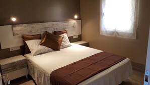 A bedroom with a bed, nightstands, and a window. - Vacation Home 'Costa Brava Experience' with Wi-Fi and Private Pool (Roses)