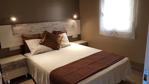 A bedroom with a bed, nightstands, and a window. - Vacation Home 'Costa Brava Experience' with Wi-Fi and Private Pool (Roses)