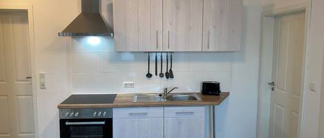 Frigorífico, placa de cocina y utensilios de cocina